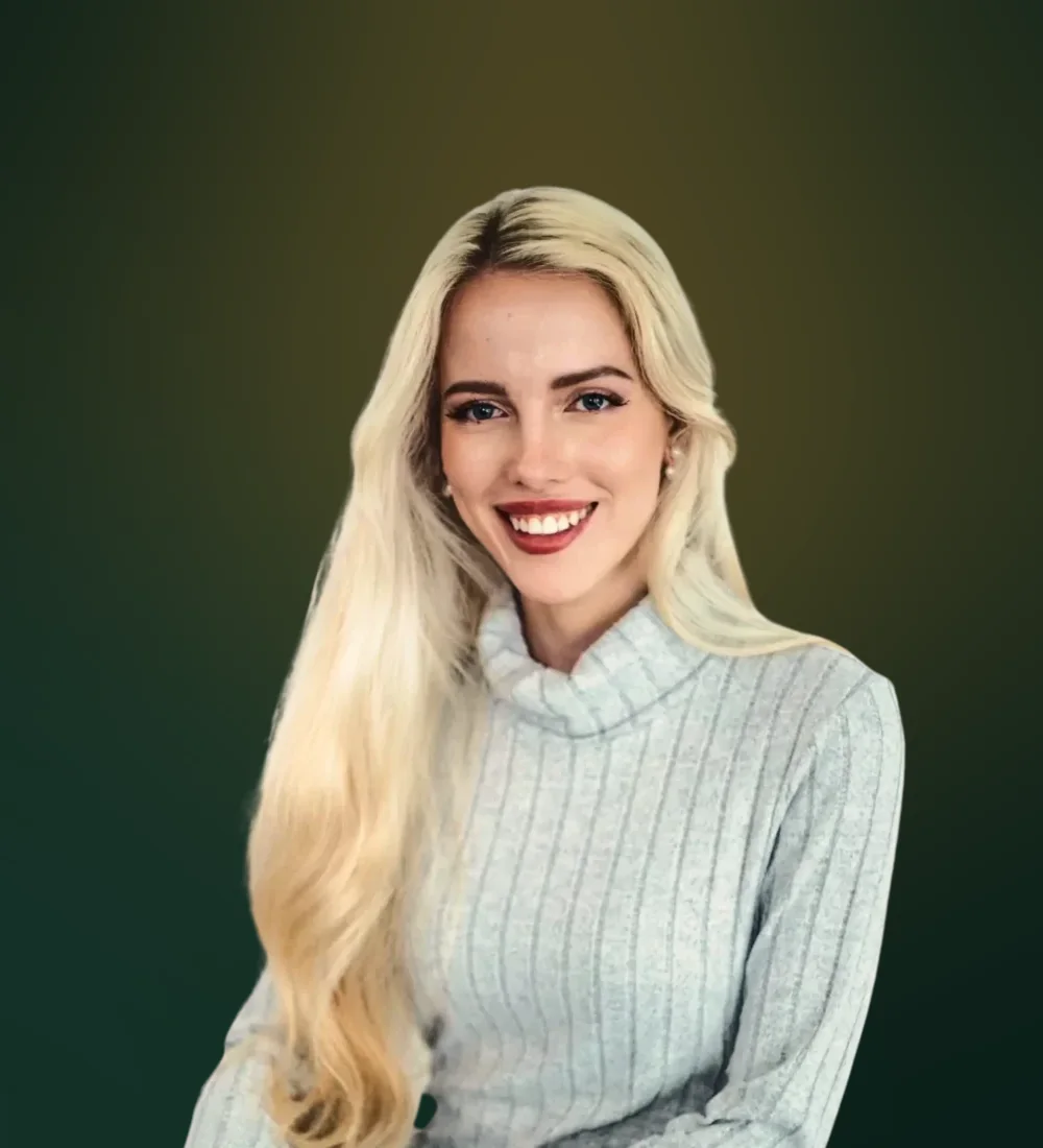 Tjaša Peterle, founder of Studio Merlin, smiling in a grey knit sweater
